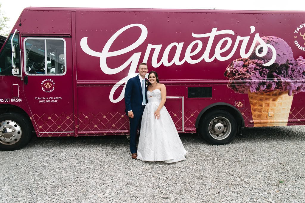 Adisyn and Carson pose in front of the Graeter’s ice cream truck at their wedding at The Grange Hall