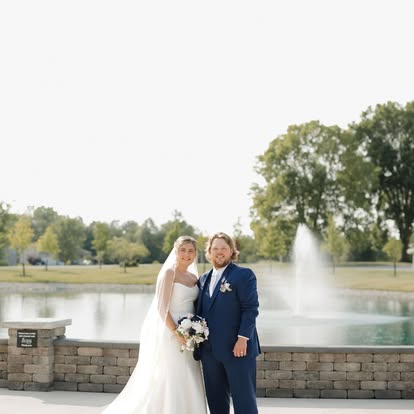 Faith and George pose in front of the pond and fountain at The Grange Hall