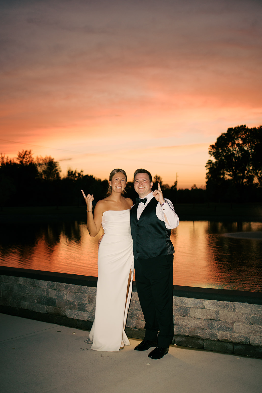 Taylor and Derek celebrating in front of the pond at sunset at The Grange Hall